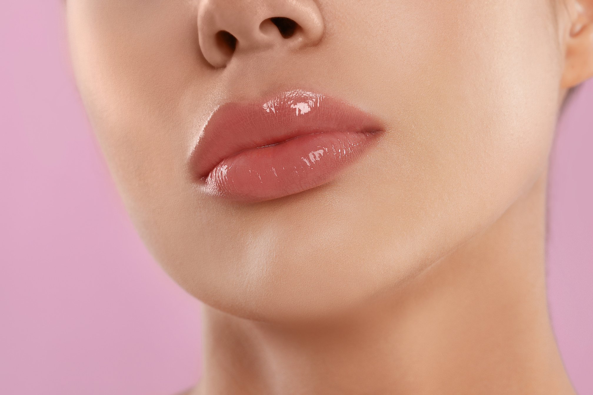 Young Woman with Beautiful Full Lips on Pink Background, Closeup